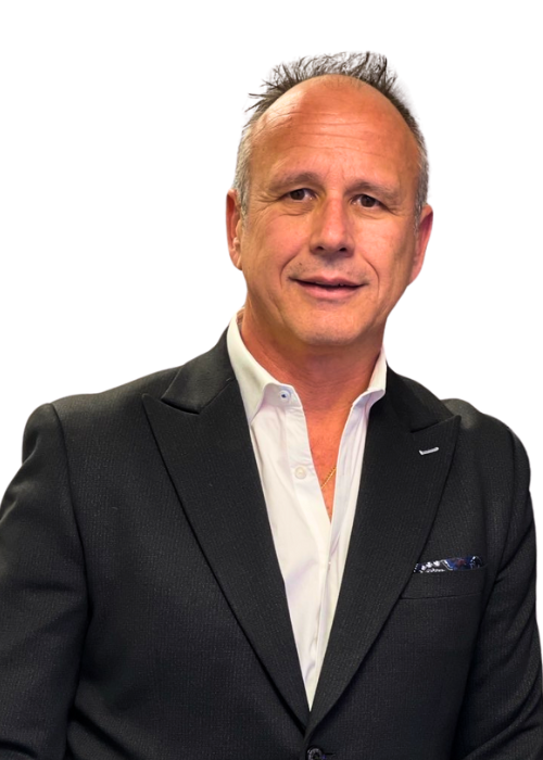 Man in black suit and white shirt, smiling, looking at the camera.