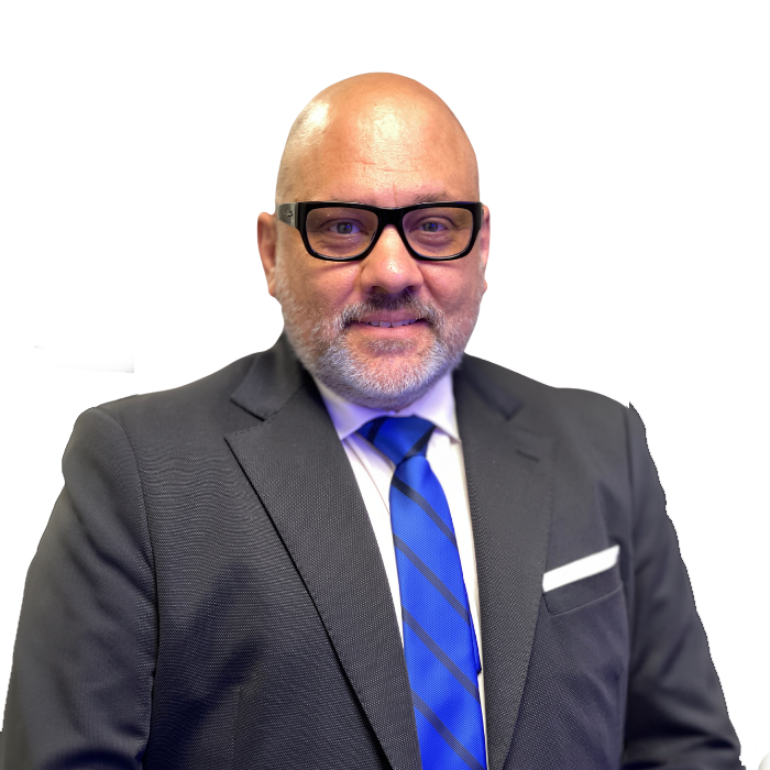 Bald man in glasses, navy suit, blue tie, white pocket square, smiling, looking at camera.