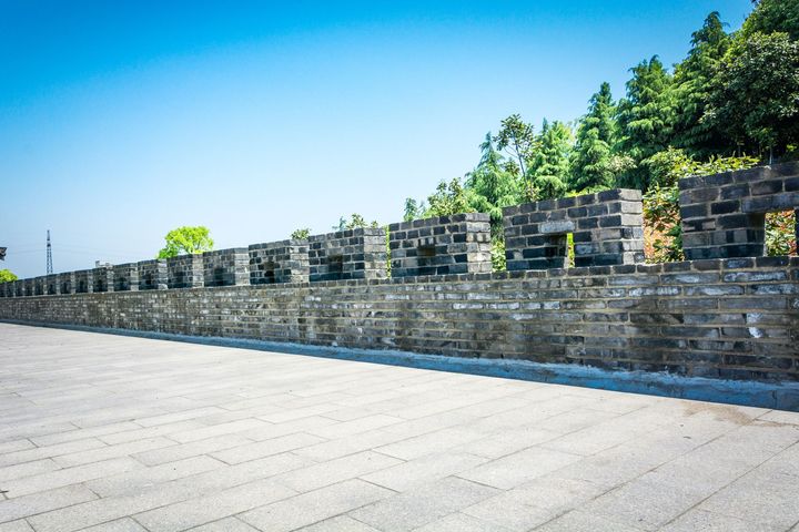 A brick wall with a blue sky in the background