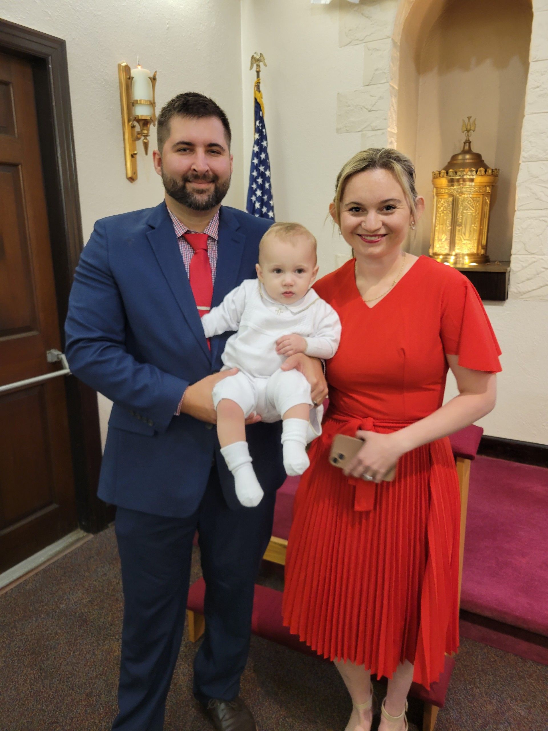 A man in a suit and tie is holding a baby
