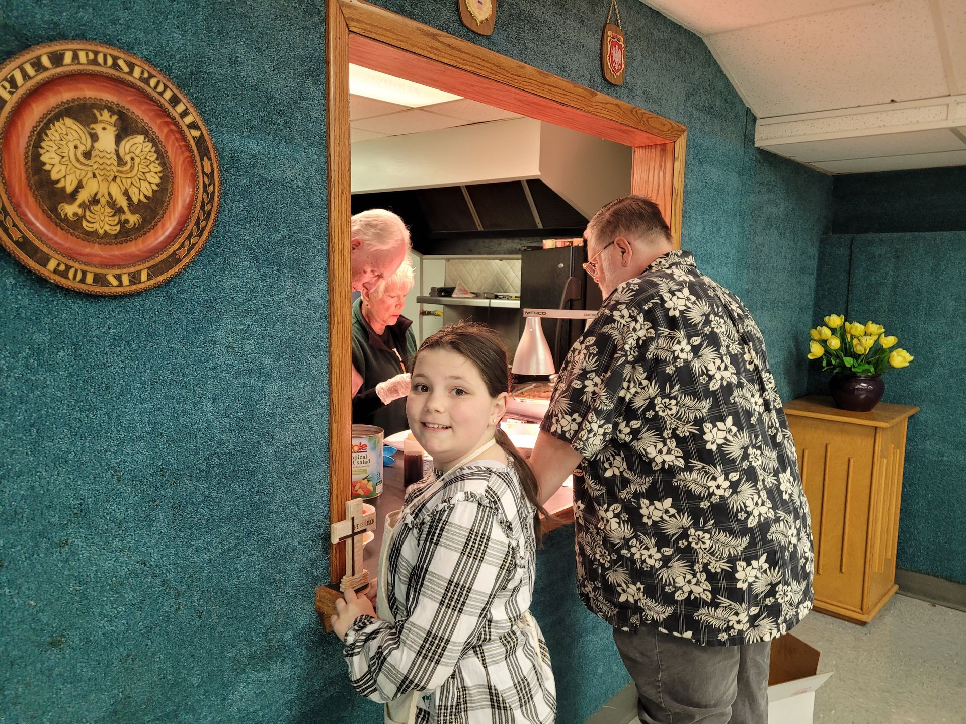A man and a boy are standing in a room with a seal on the wall.