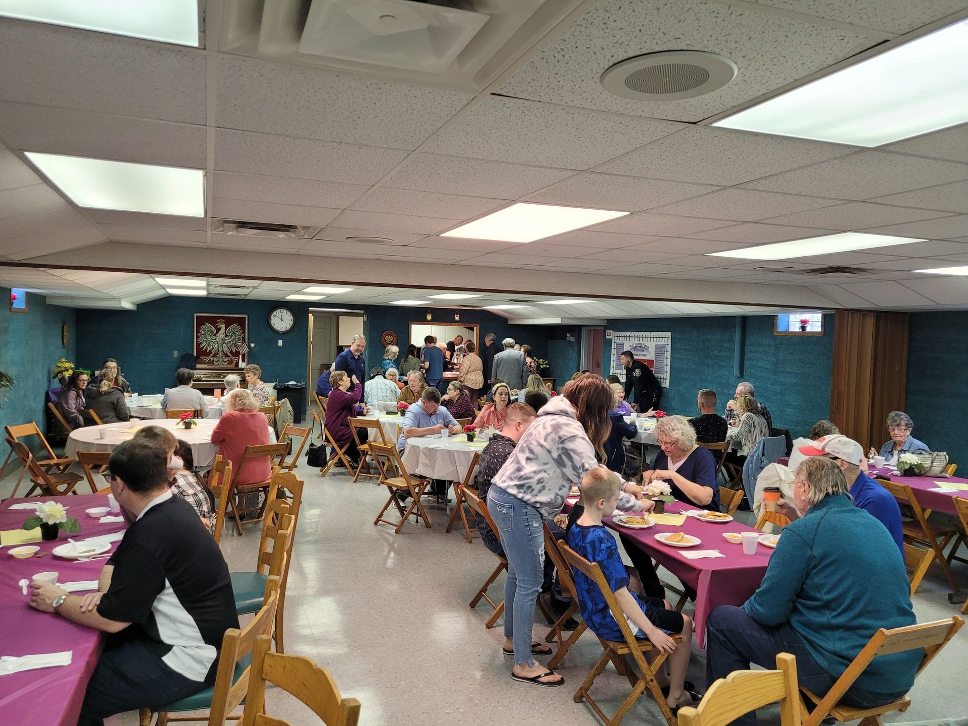 A group of people are sitting at tables in a large room.