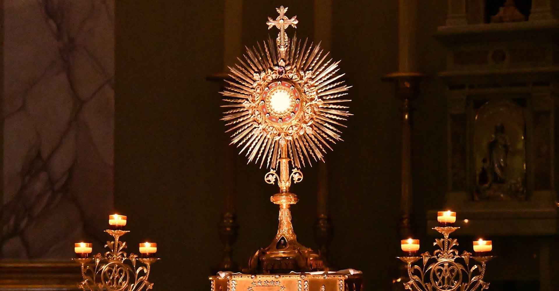A church with candles and a statue of jesus on the altar.