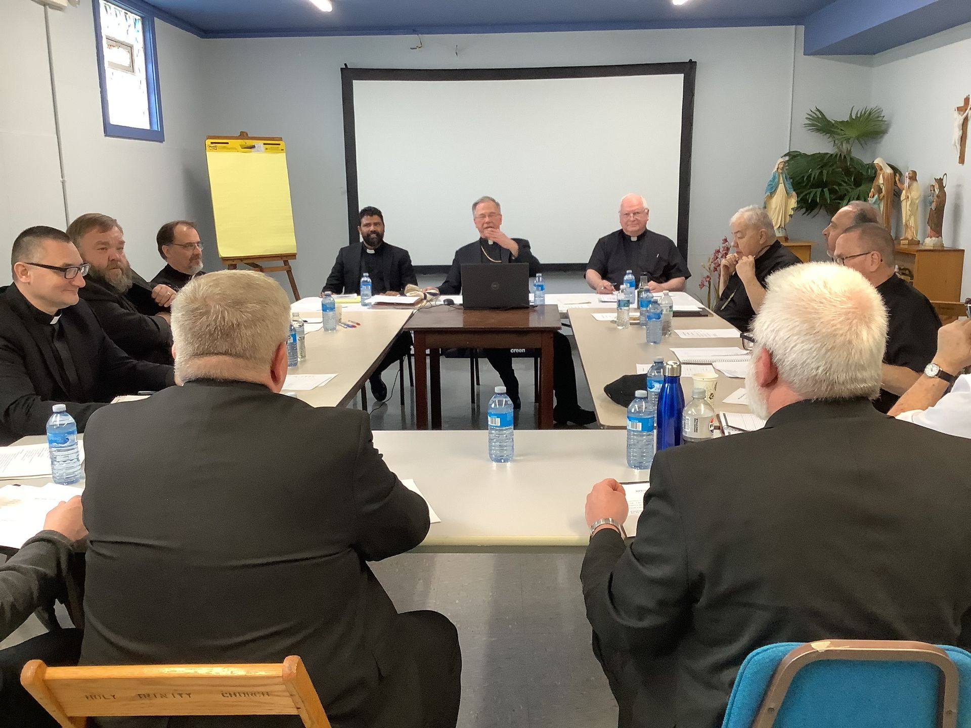 A group of men are sitting around a table having a meeting