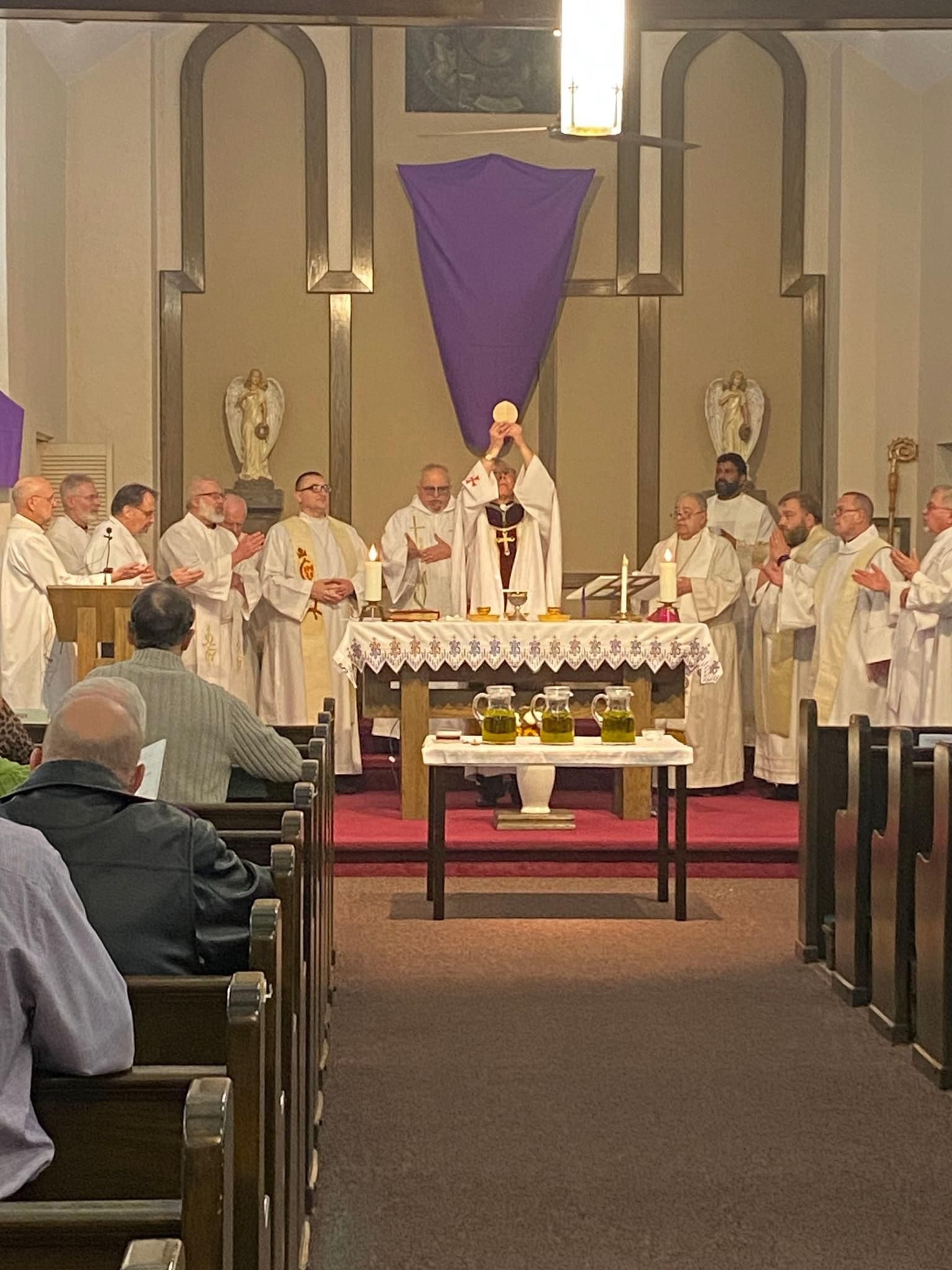 A group of priests are standing around an altar in a church.