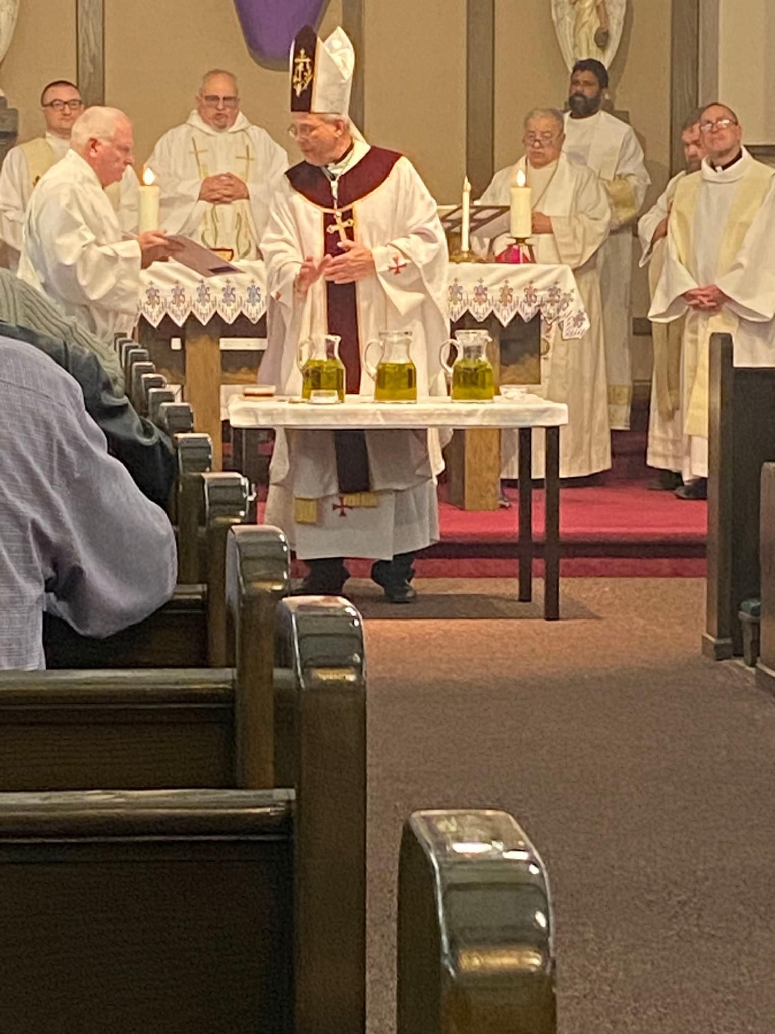 A group of priests are standing around a table in a church.