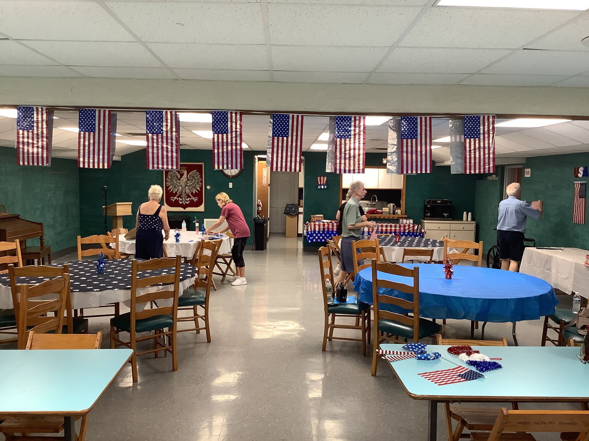 A large room with tables and chairs and american flags hanging from the ceiling