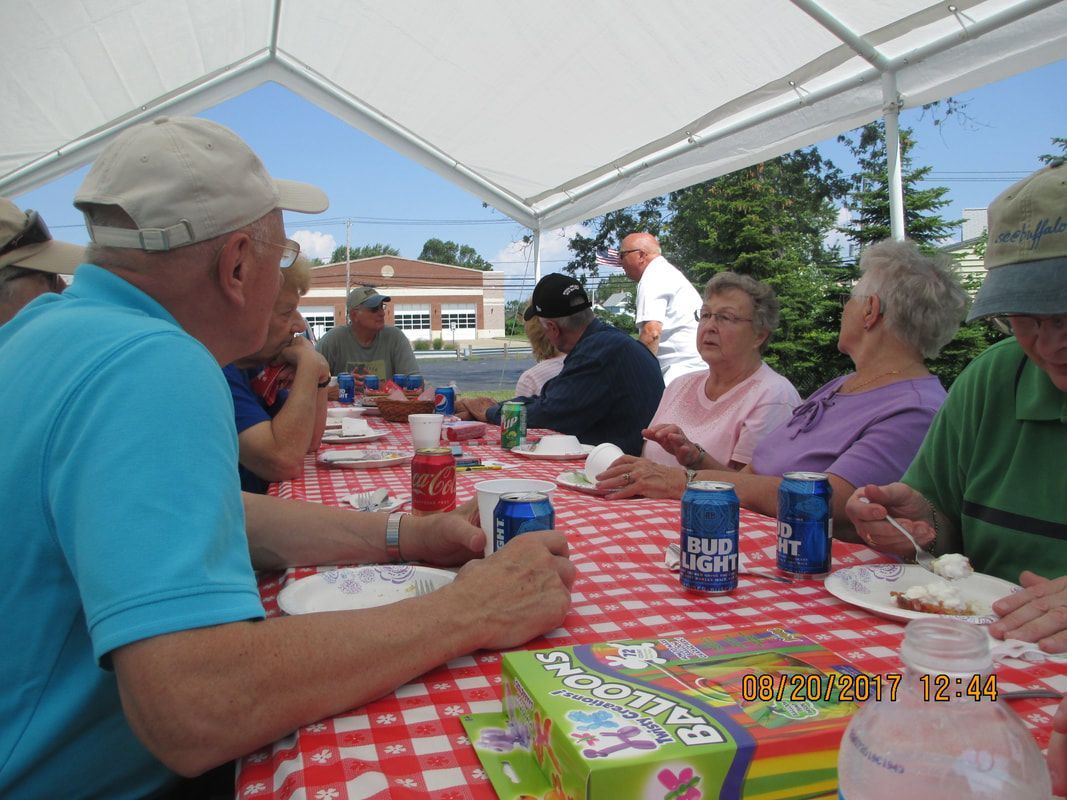 A group of people are sitting at a table with bud light cans