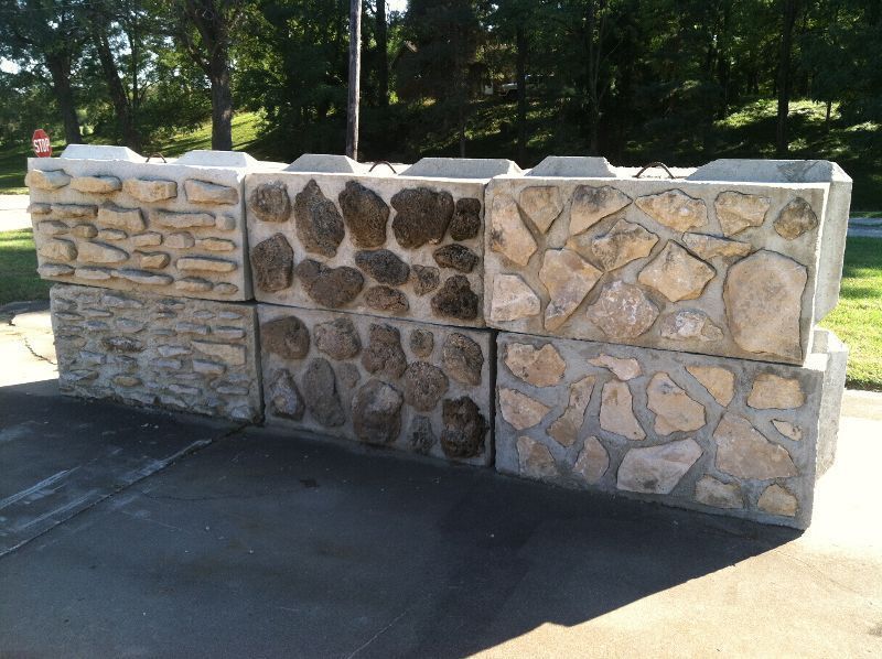 Stacked concrete blocks with different stone textures, outdoors.
