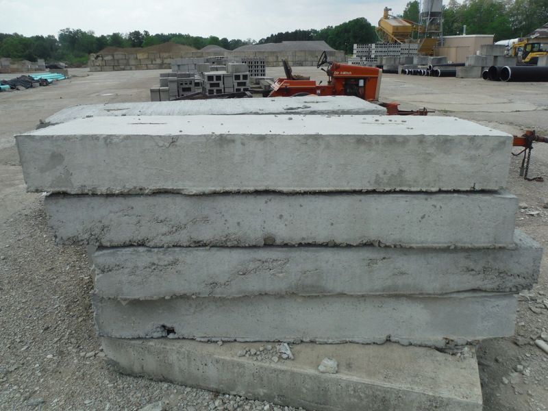 Stack of gray concrete slabs on an outdoor construction site.