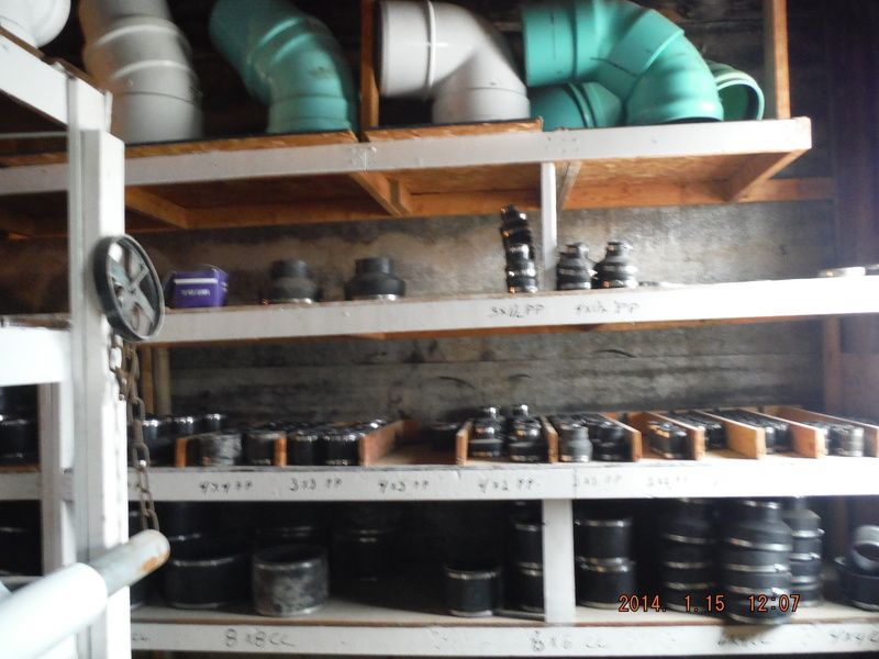 Shelves stocked with various plumbing pipes and fittings, organized by size.