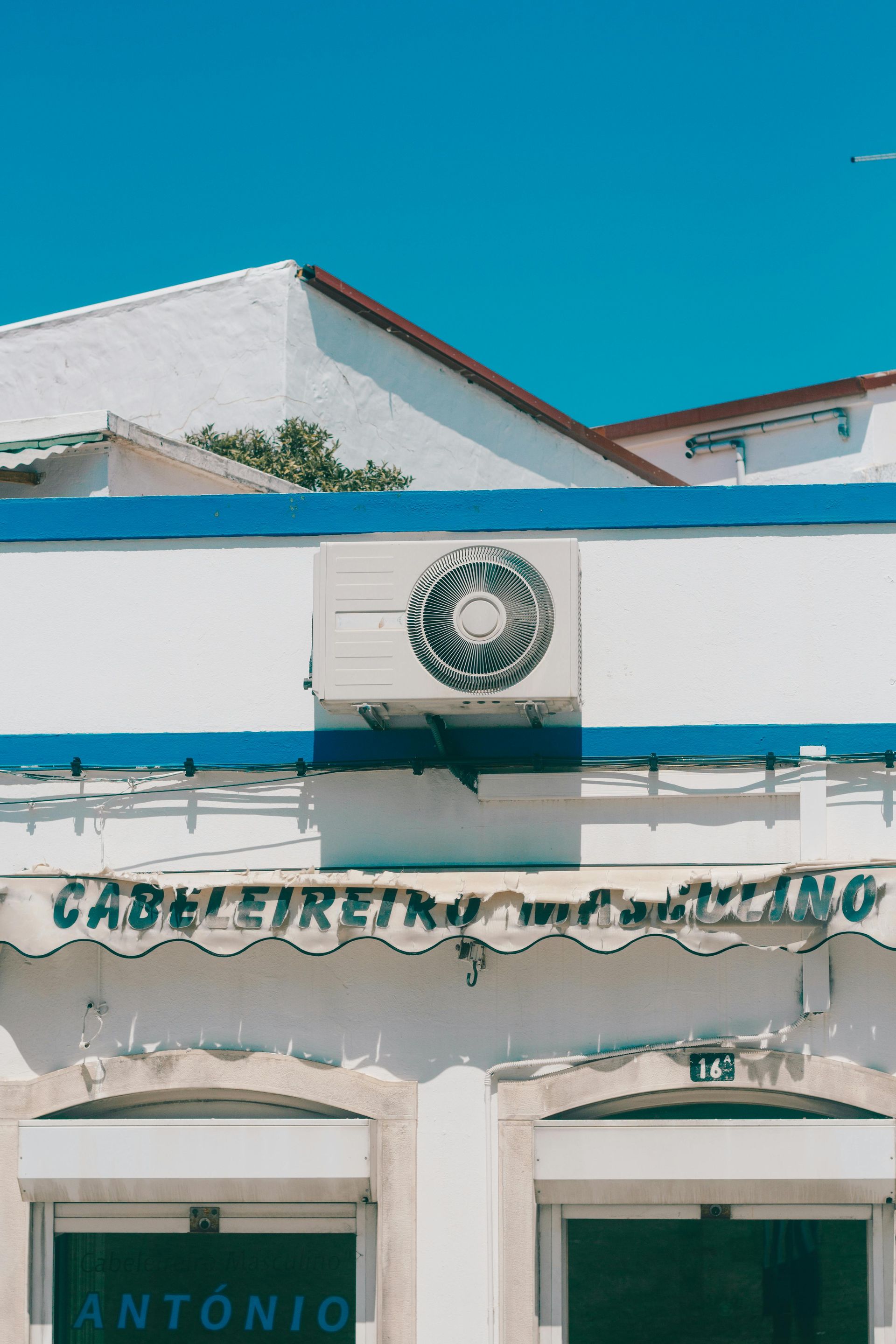A white and blue building with a wreath on the top of it.