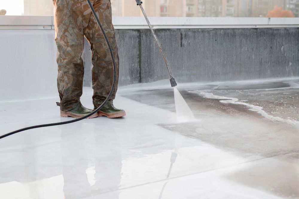 A man is using a high pressure washer to clean a roof. — Soakd In Kariong, NSW