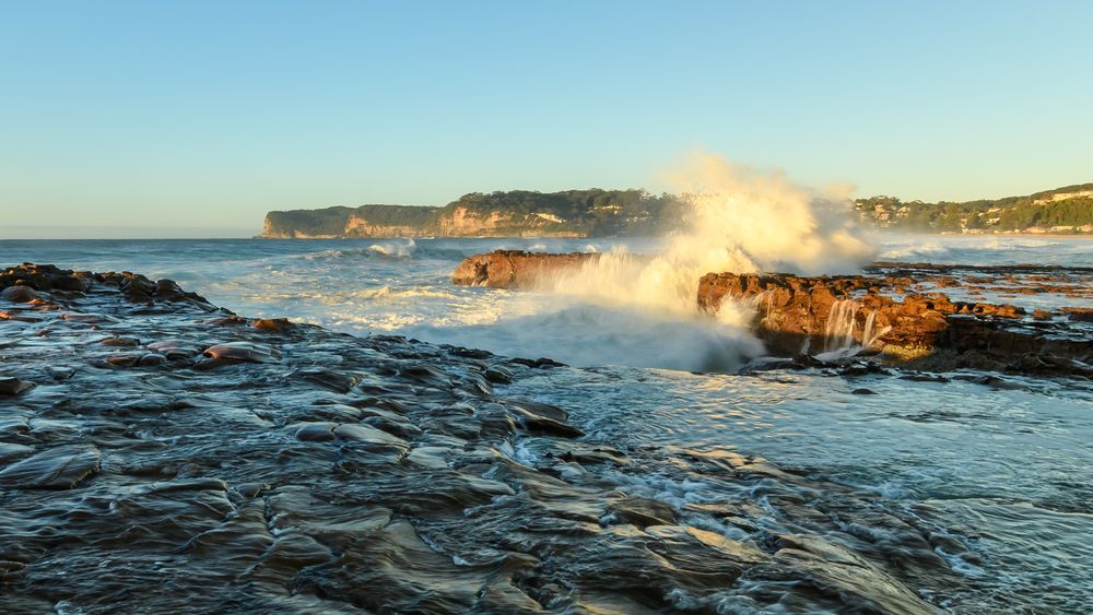 Waves Crashing on Rocky Shore at Sunset, Cliffs in the Background — SOAKD Exterior Cleaning in Avoca Beach, NSW