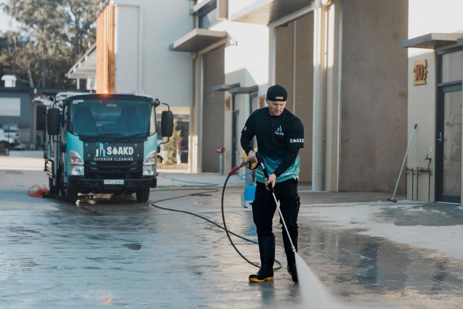 Man Power Washing a Concrete Surface — SOAKD Exterior Cleaning in Kariong, NSW