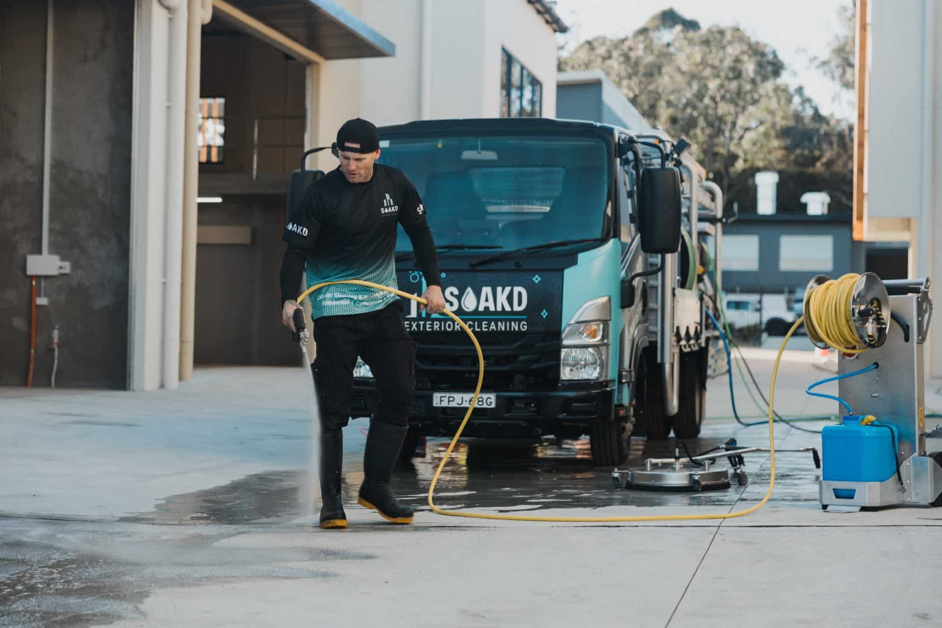 Man with A Pressure Washer Hose by A Cleaning Truck — Soakd In Newcastle, NSW