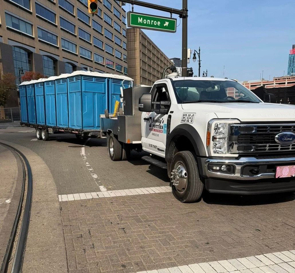 Smiling worker with arms crossed, wearing a white hard hat and blue overalls.