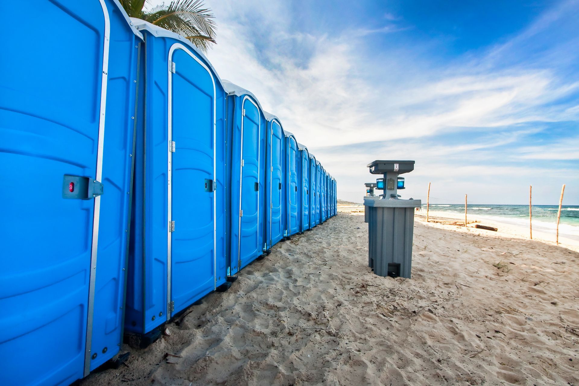 Blue beach porta potties showcasing luxury restroom trailers for clean and organized event needs