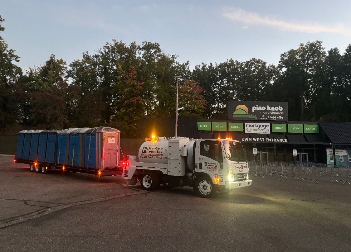 Teal portable toilet on a brick-paved surface, with a brick building in the background. Teal portable toilet on a brick-paved surface, with a brick building in the background.