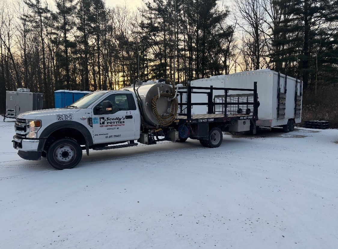 White truck with a large tank and a rectangular structure on a flatbed, parked in a snowy area. Trees in the background. White truck with a large tank and a rectangular structure on a flatbed, parked in a snowy area. Trees in the background.