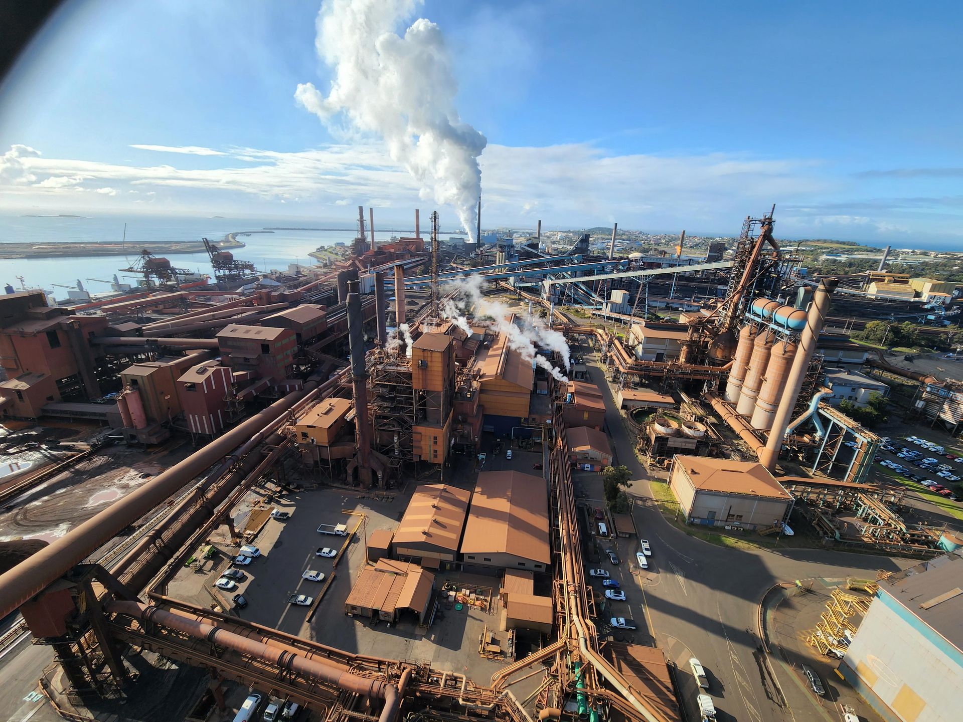 an aerial view of a factory with smoke coming out of the chimneys