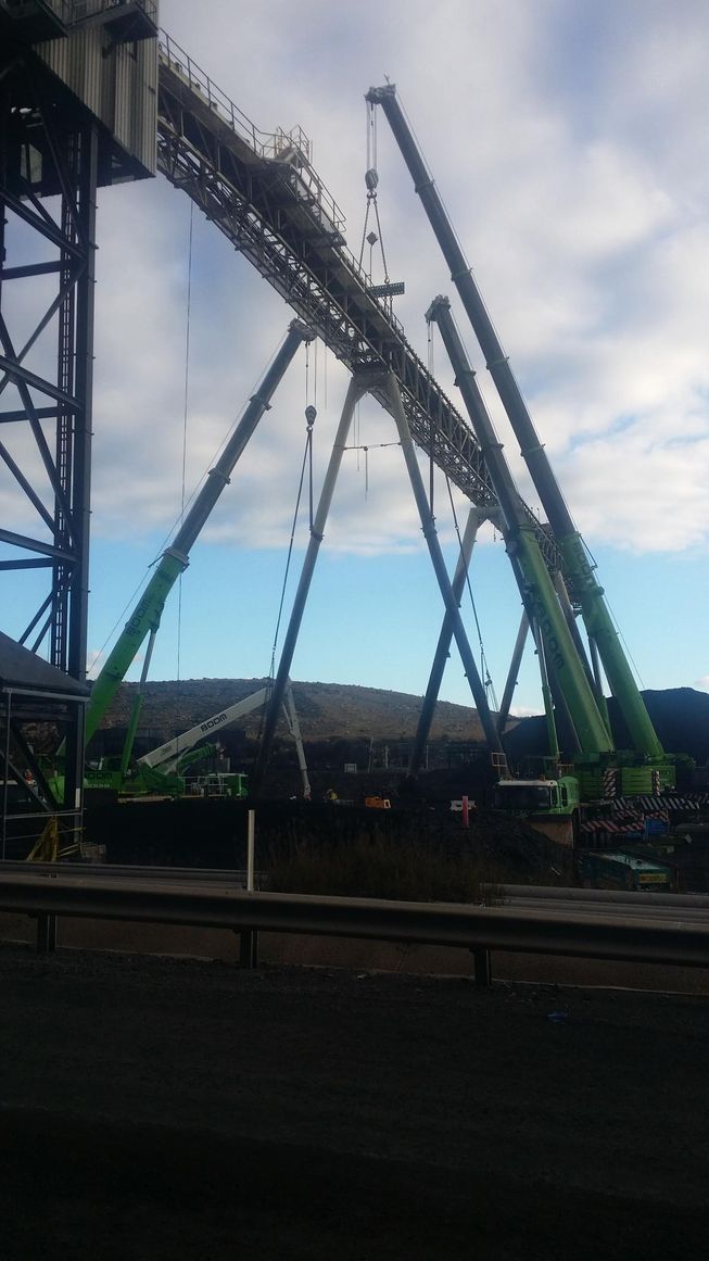 a bunch of cranes are being used to build a trestle