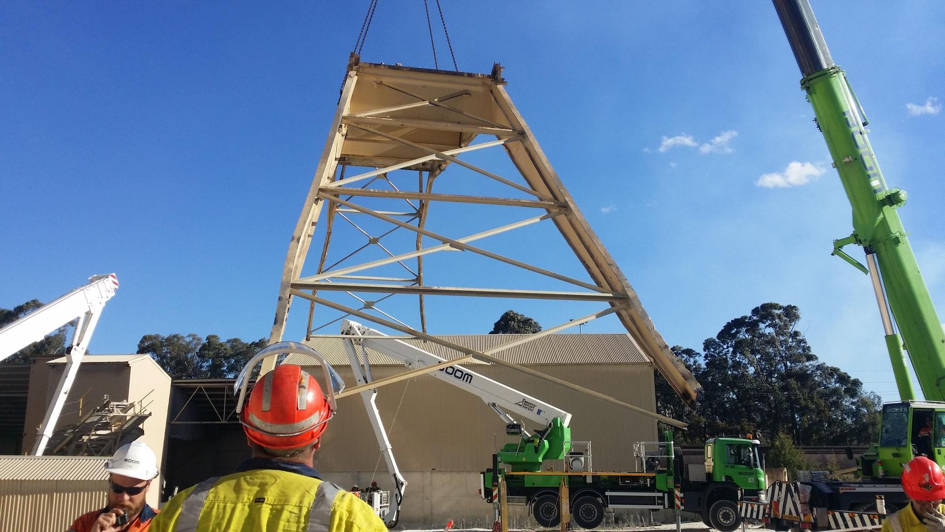 a man in a hard hat is standing in front of a crane
