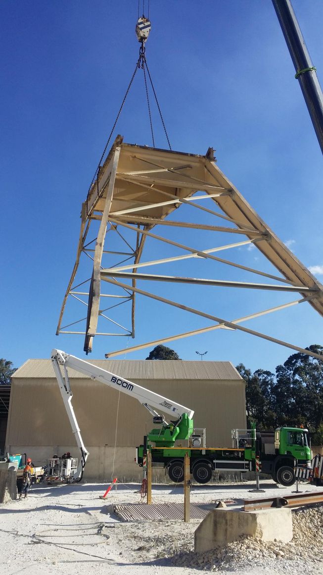 a crane is lifting a large piece of metal into the air
