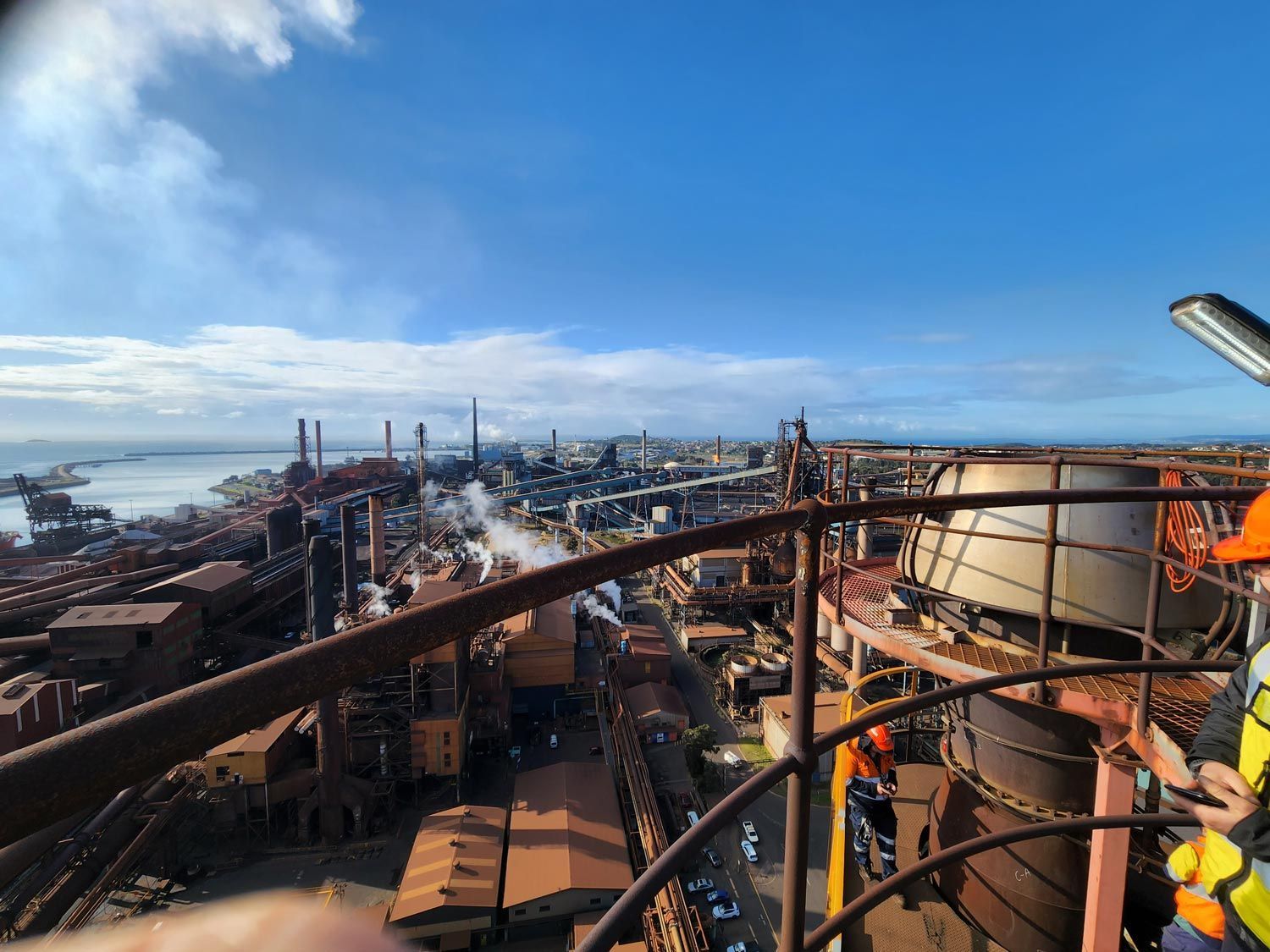 a man in an orange hard hat is standing on top of a factory