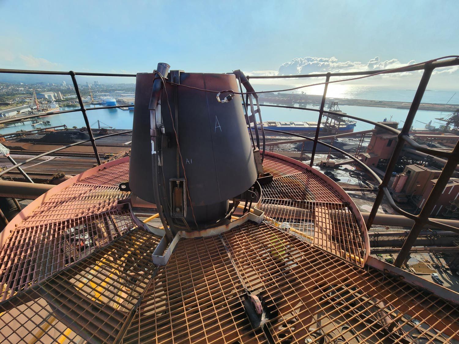 a metal staircase leading up to a tower with a bucket on top of it