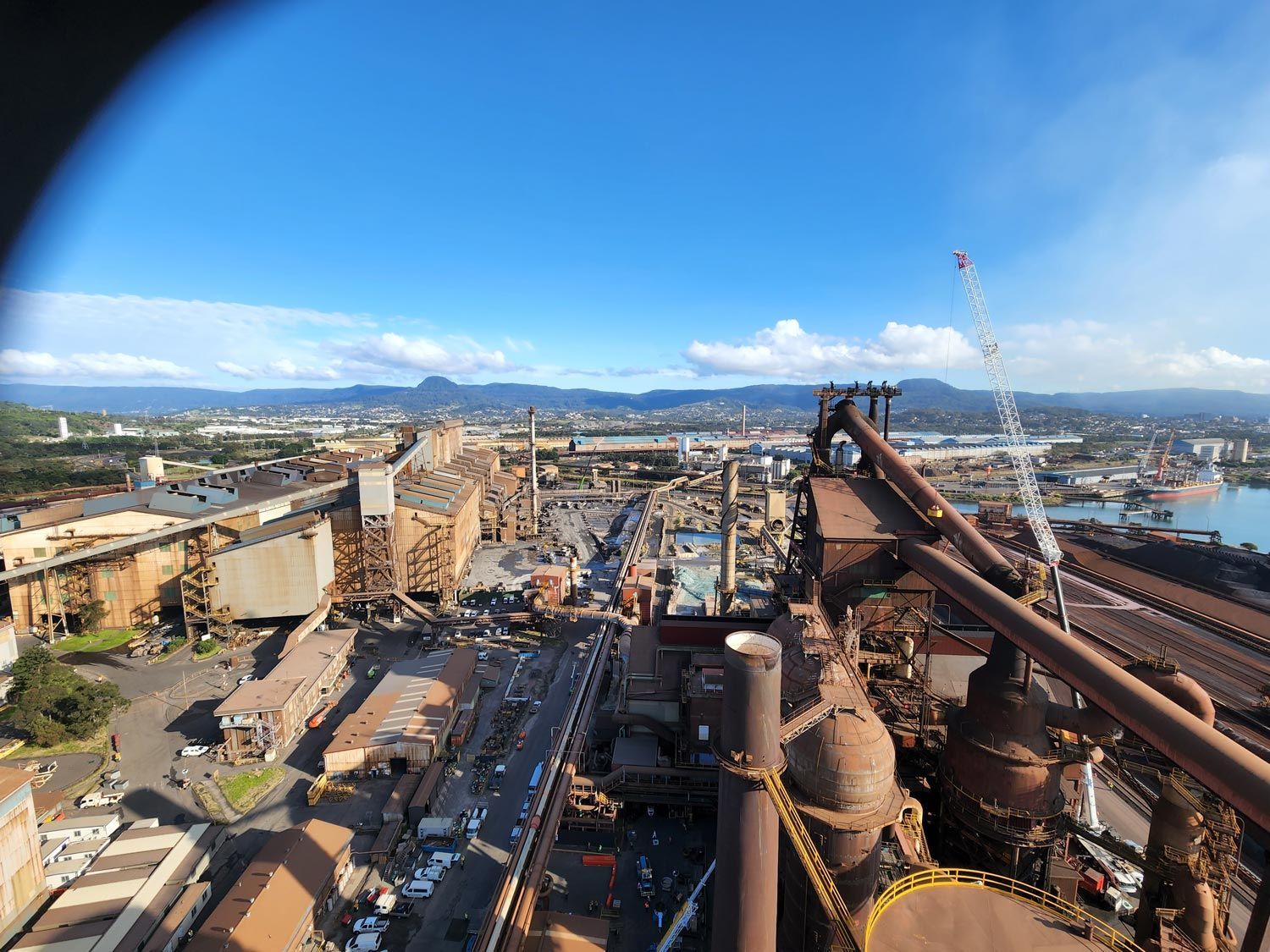 an aerial view of a factory with a city in the background