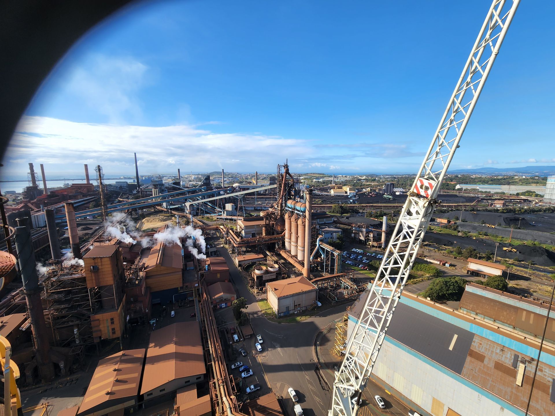 an aerial view of a factory with a crane in the foreground