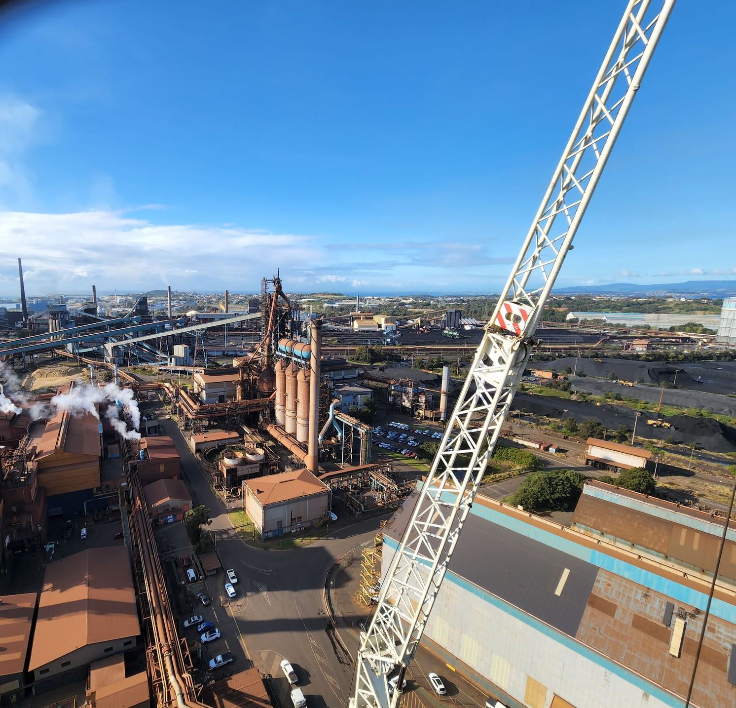 an aerial view of a factory with a crane in the foreground