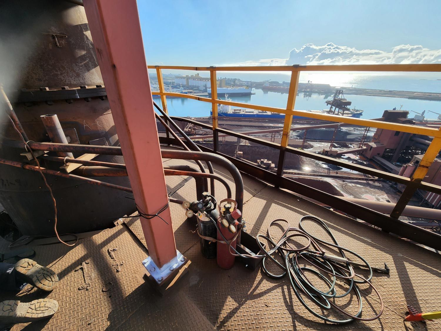 a hose is laying on the ground next to a railing on top of a building
