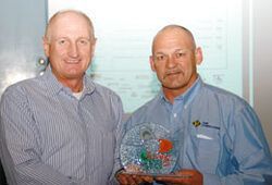 two men are standing next to each other holding a trophy