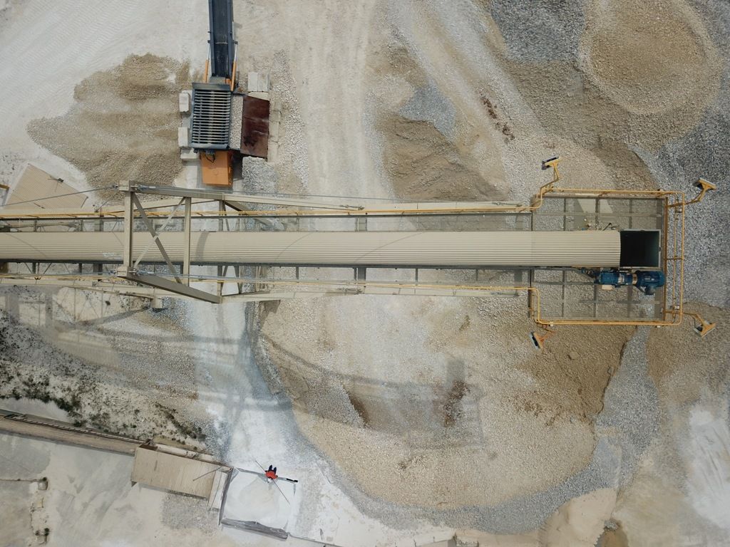 an aerial view of a conveyor belt in a quarry