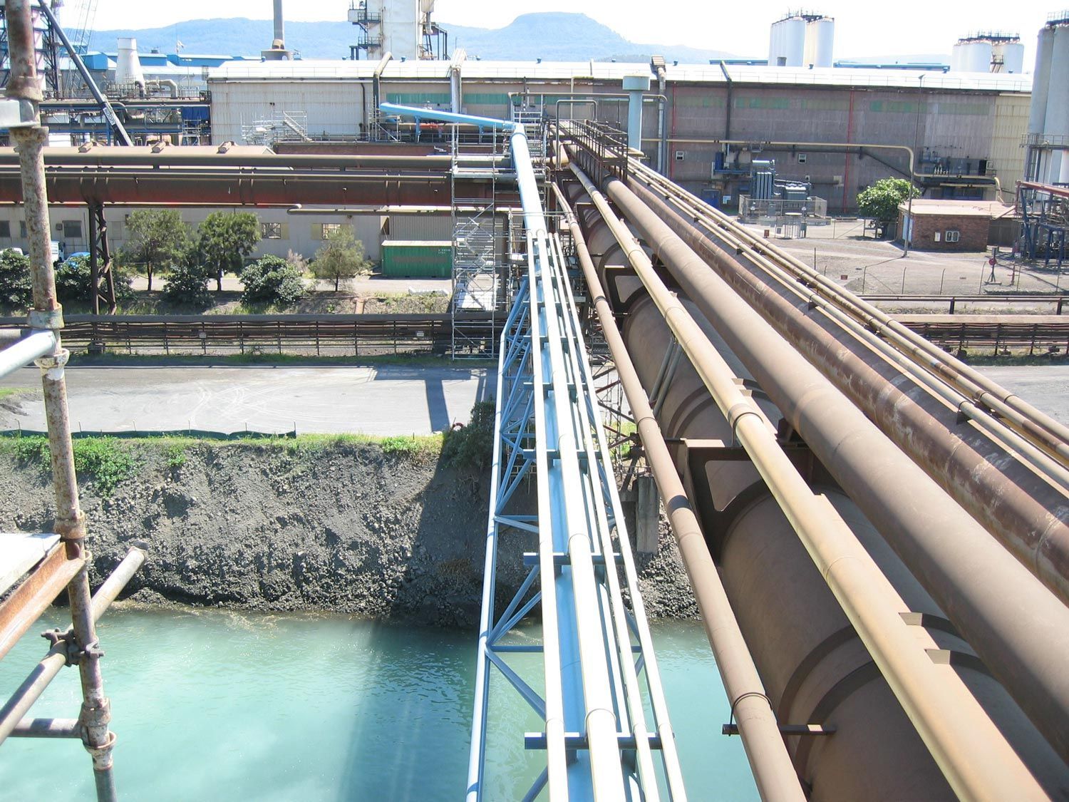 a bridge with pipes going over a body of water