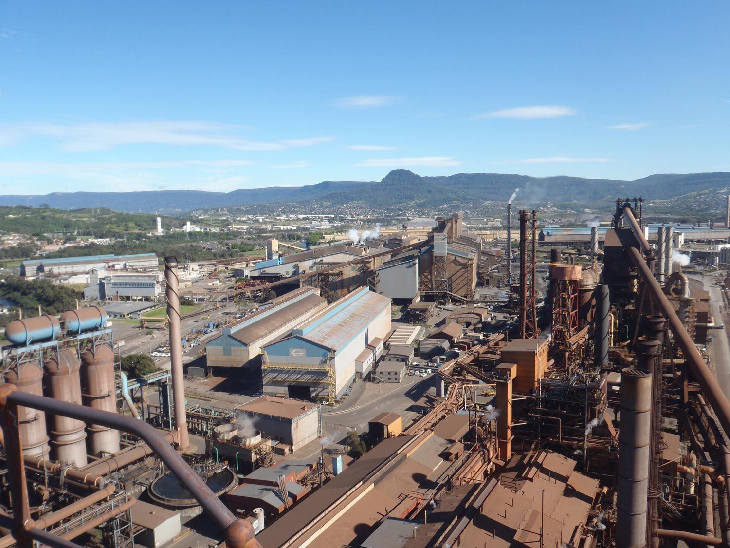 an aerial view of a factory with mountains in the background