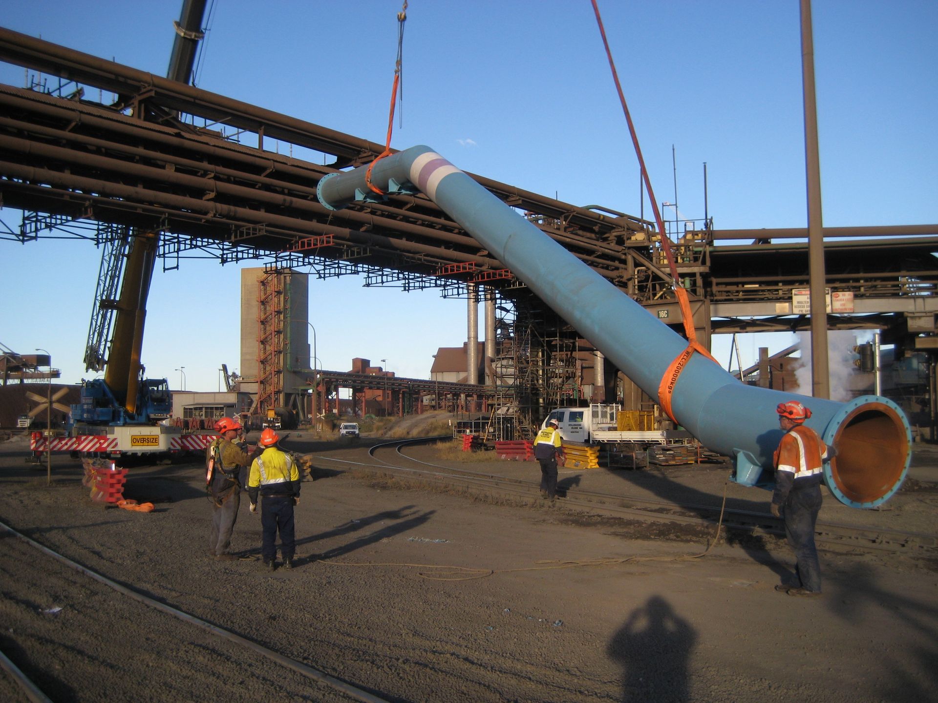 a large blue pipe is being lifted by a crane