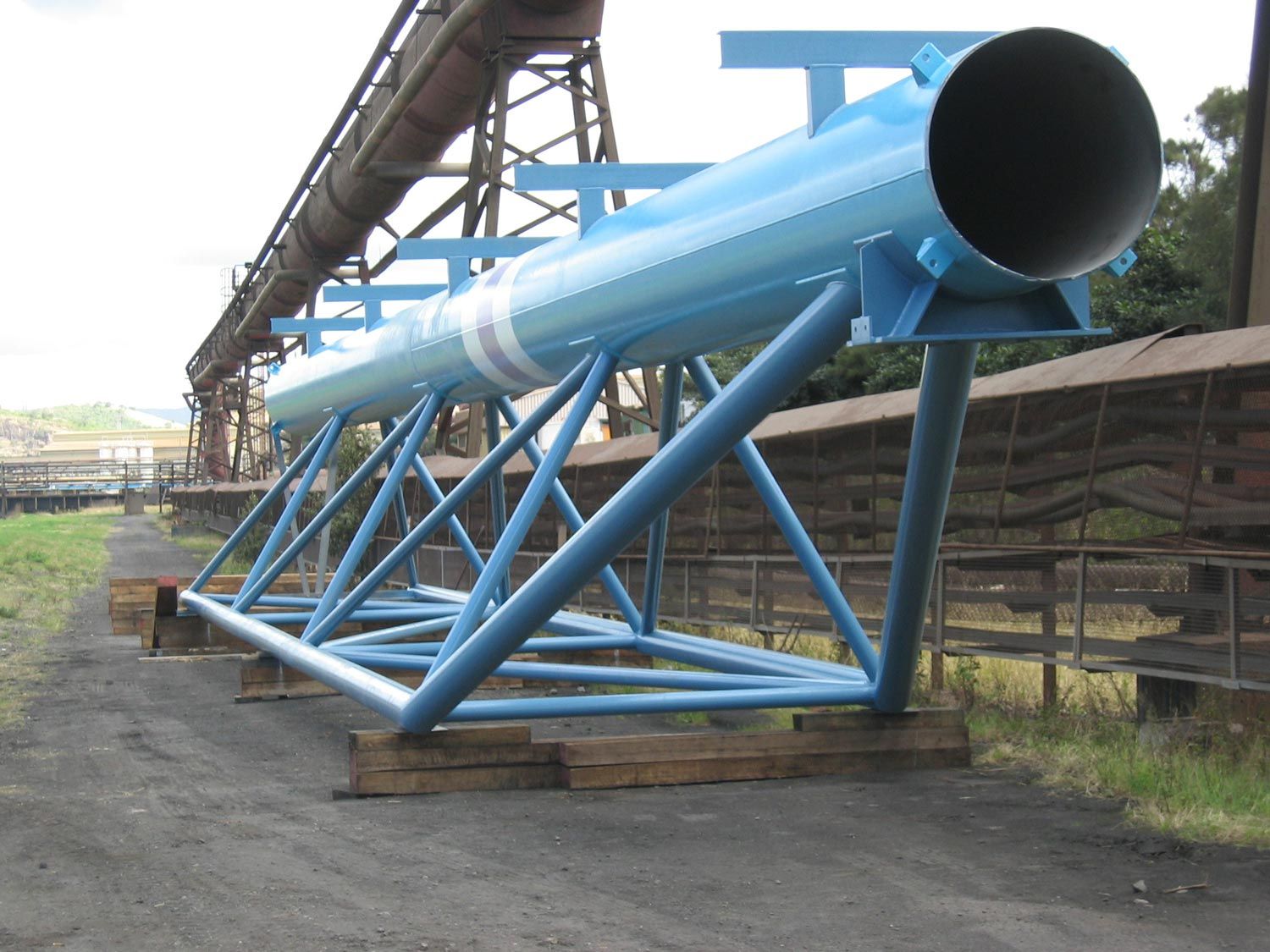 a large pipe is sitting on top of a blue metal structure