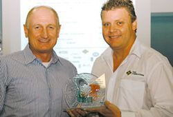 two men are standing next to each other holding a trophy