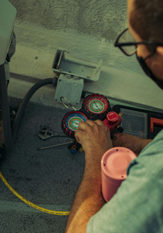 A man wearing a mask is working on a machine.
