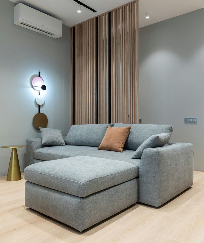 A living room with a large sectional couch and ottoman.