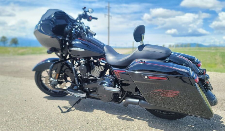 A black harley davidson motorcycle is parked on the side of the road.