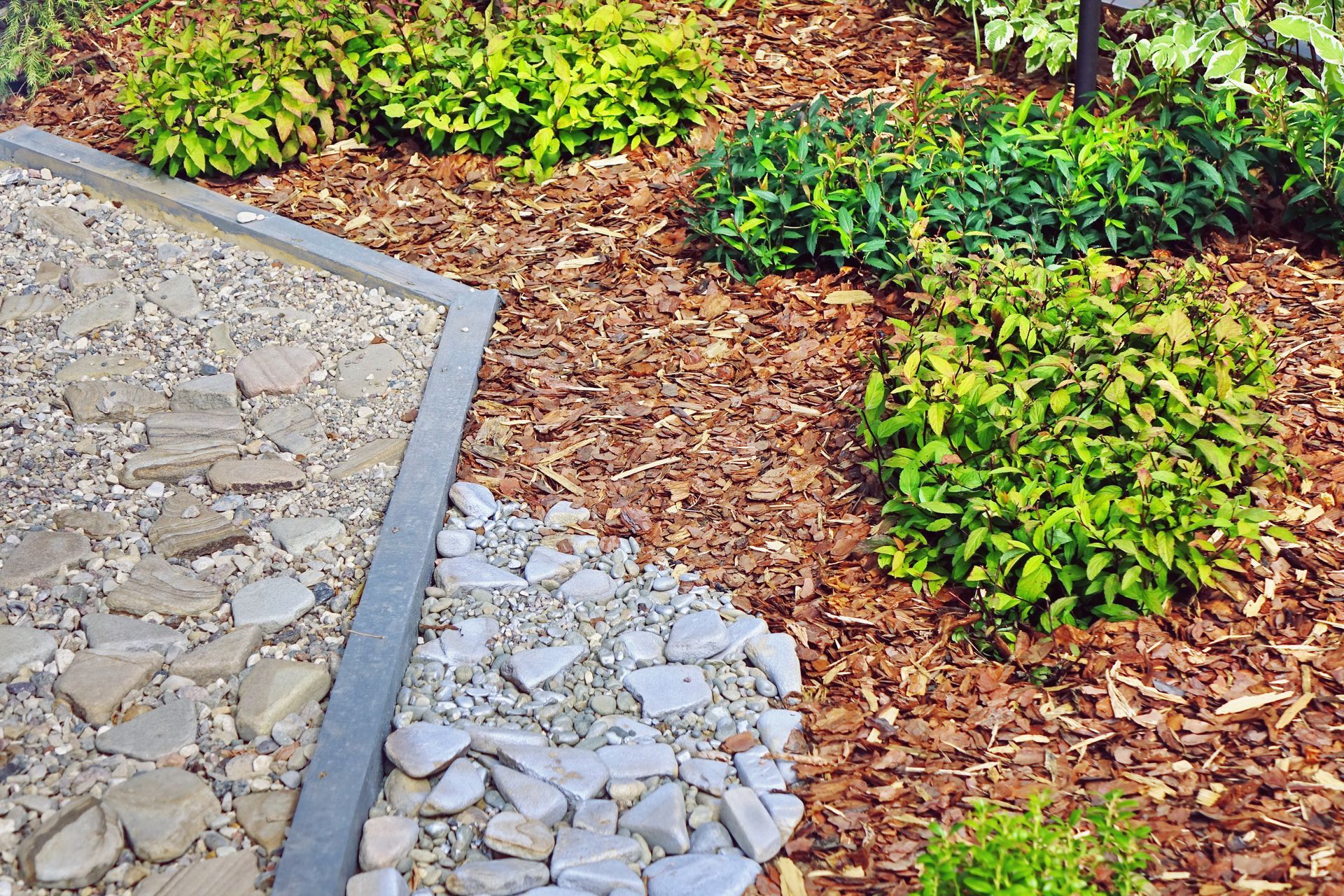 A paved stone walkway borders a garden bed