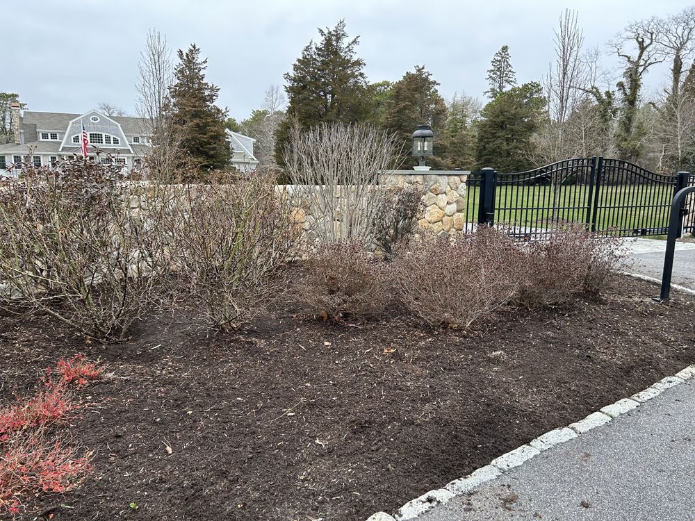 A Fenced In Area With Bushes And A Gate — Hyannis, MA — DF Landscaping