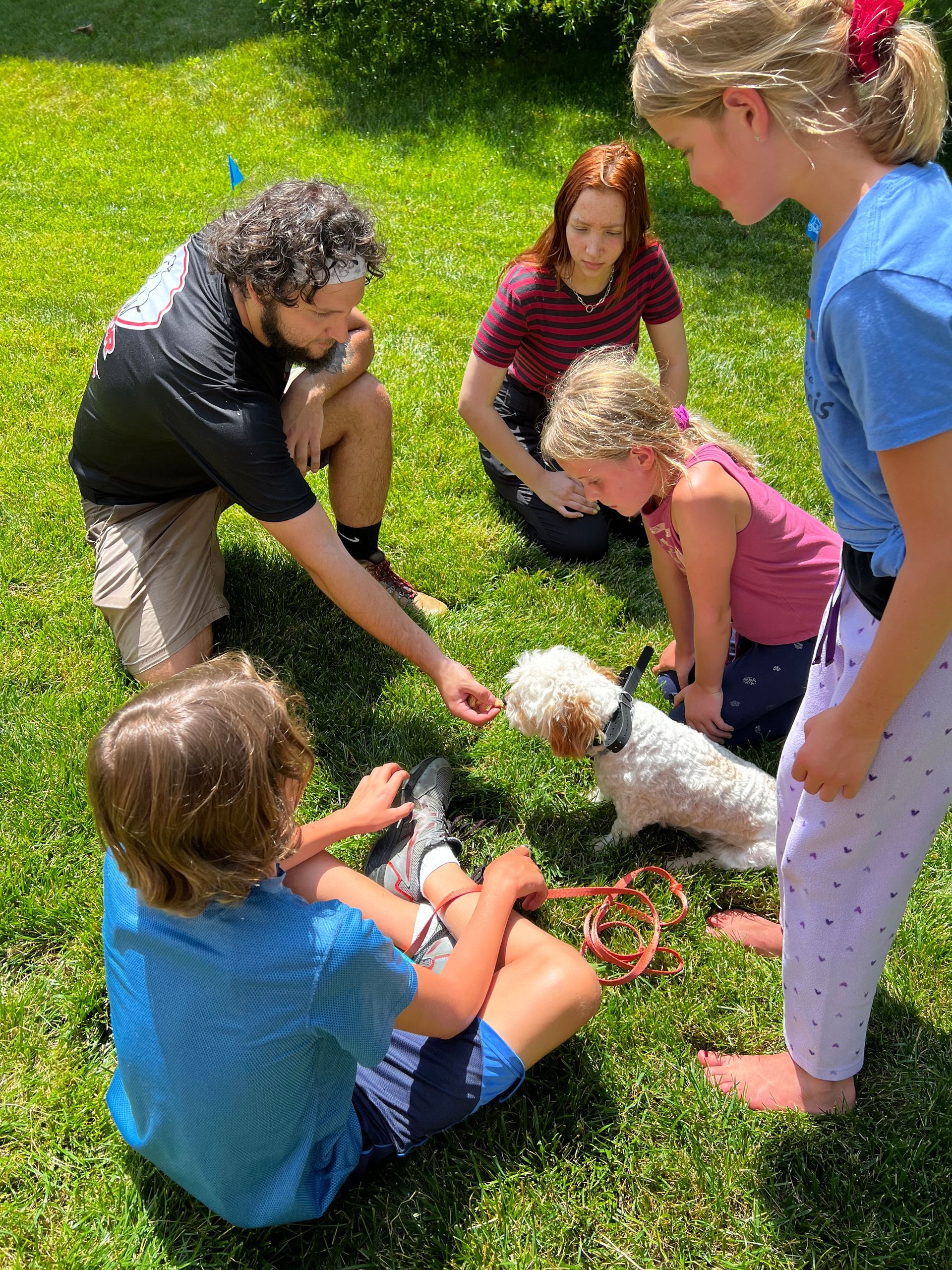 a guy teaching kids how to train a dog to a invisible dog fence system