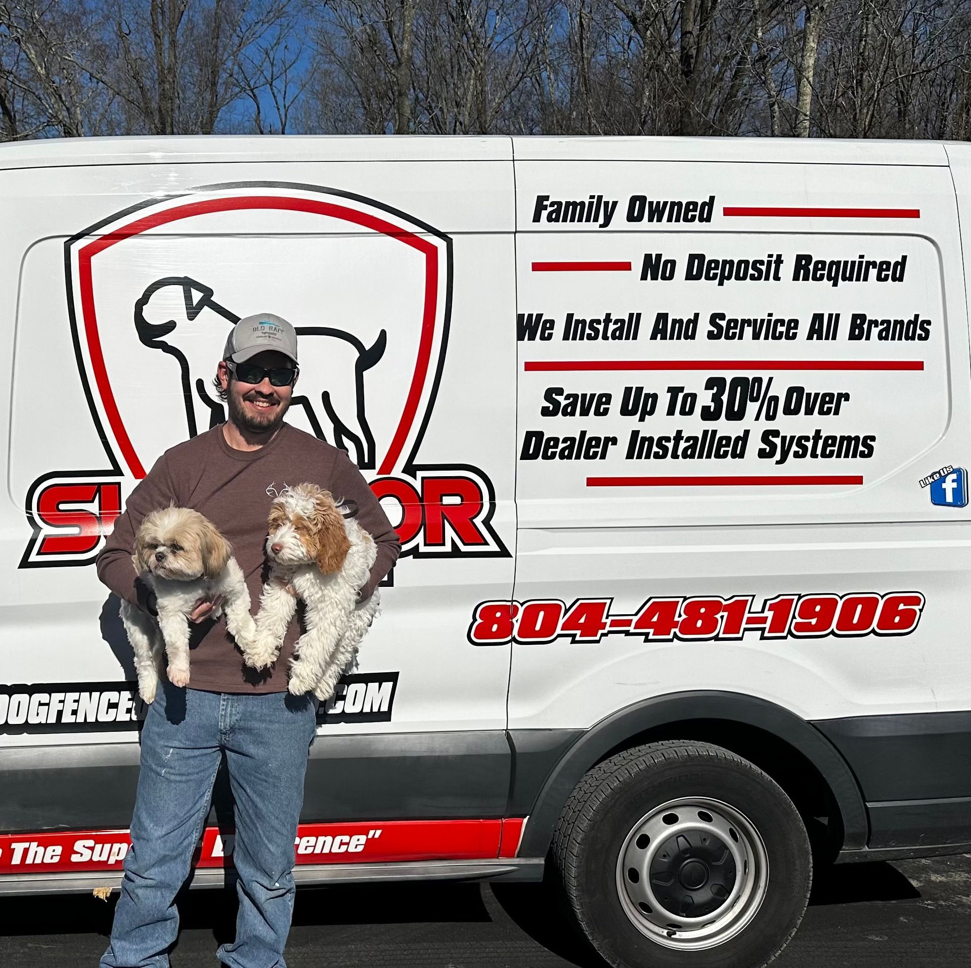 Man holding two small dogs in front of a white van with