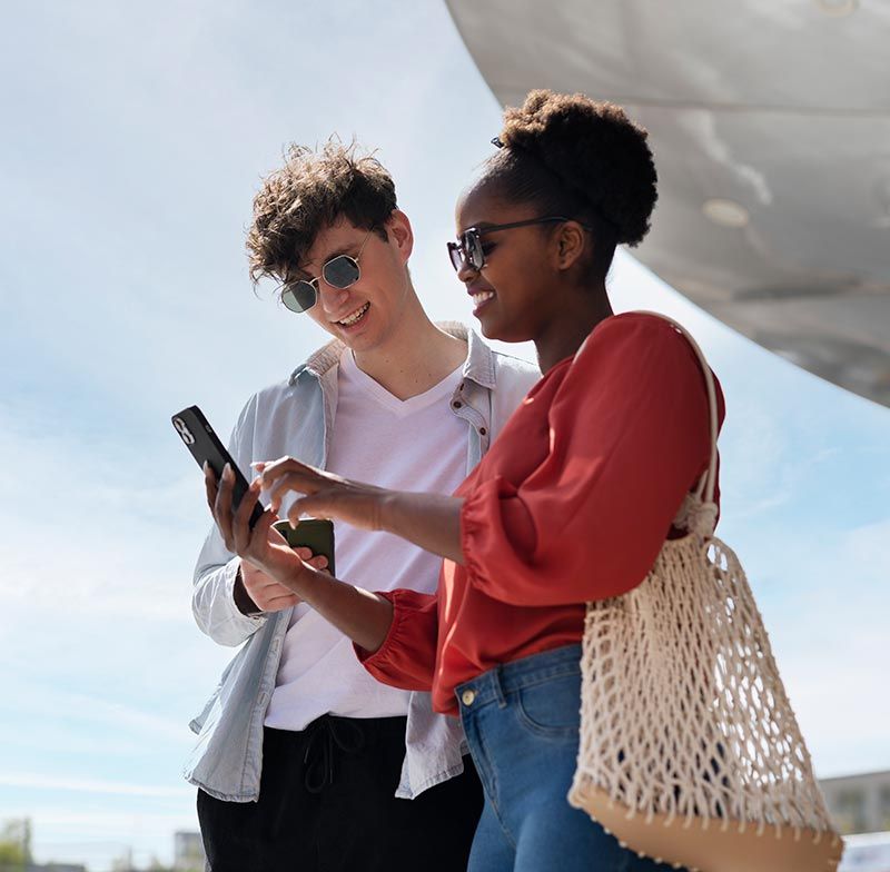 A man and a woman are looking at a cell phone together