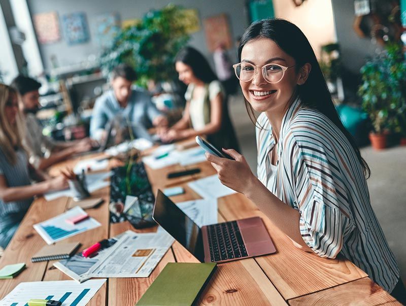 A woman is sitting at a table with a laptop and a credit card.